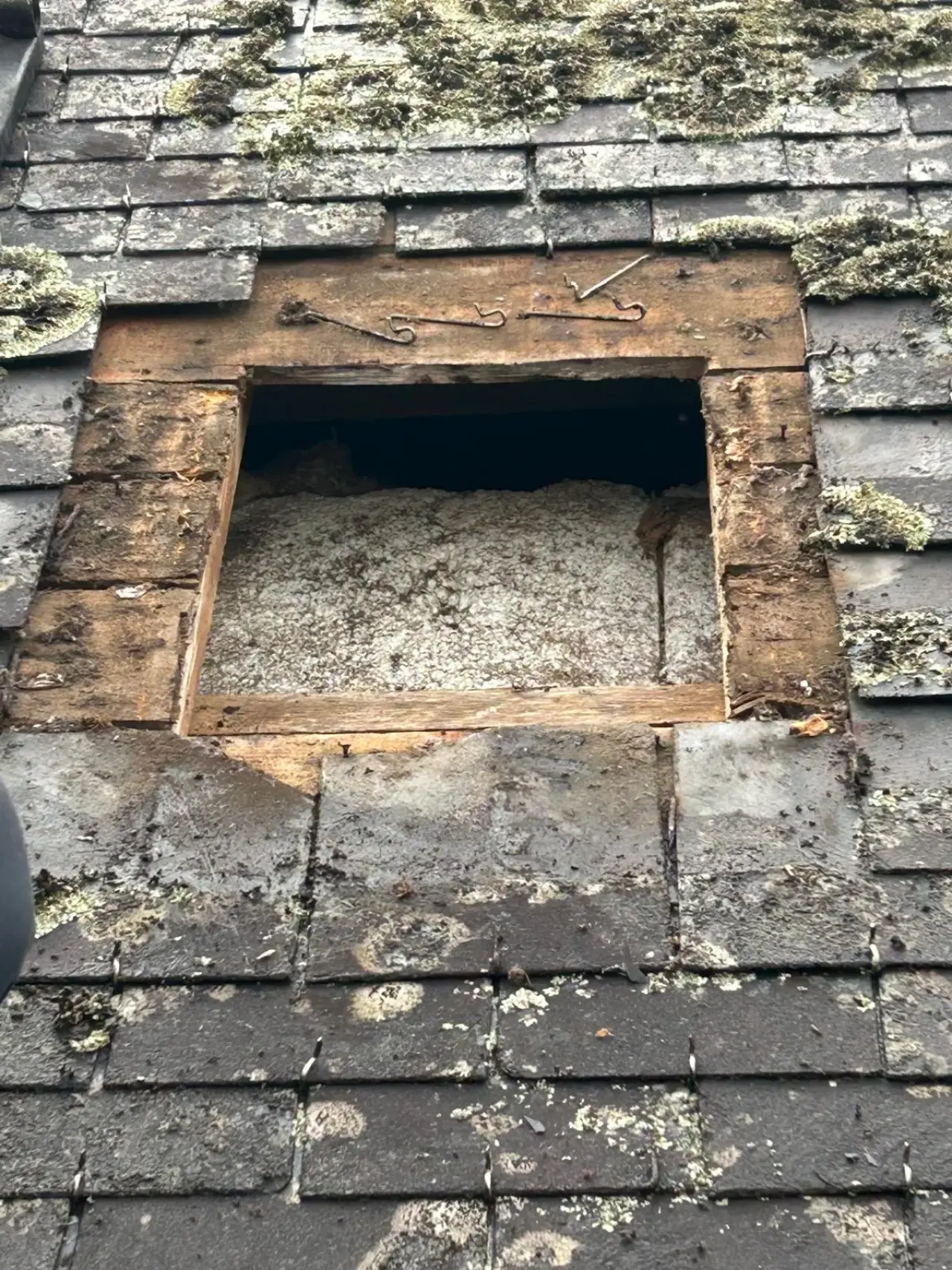 Ouverture pratiquée dans une toiture en ardoises, voligeage apparent