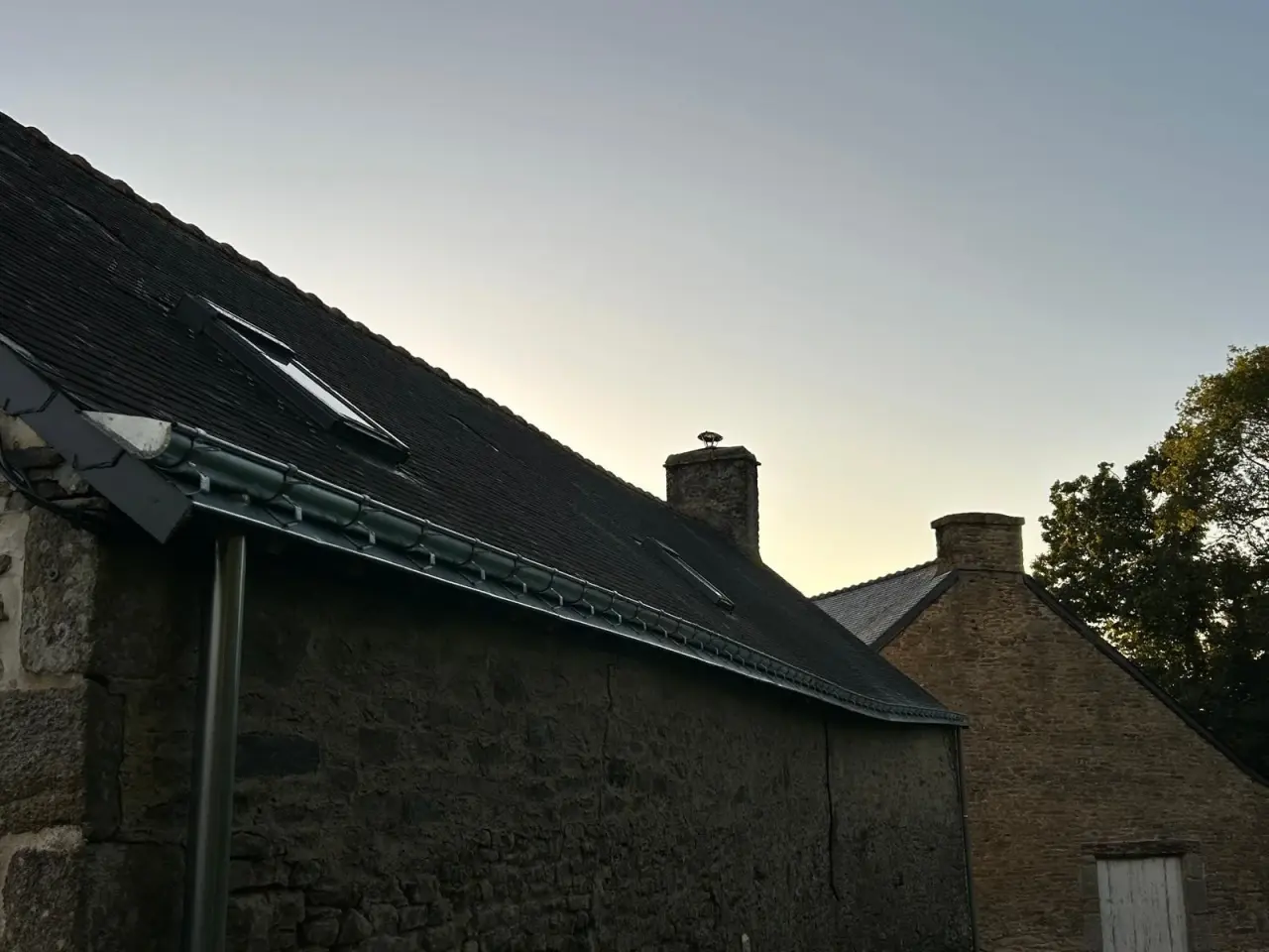 Gouttière neuve posée en rive de toiture, photo prise au crépuscule