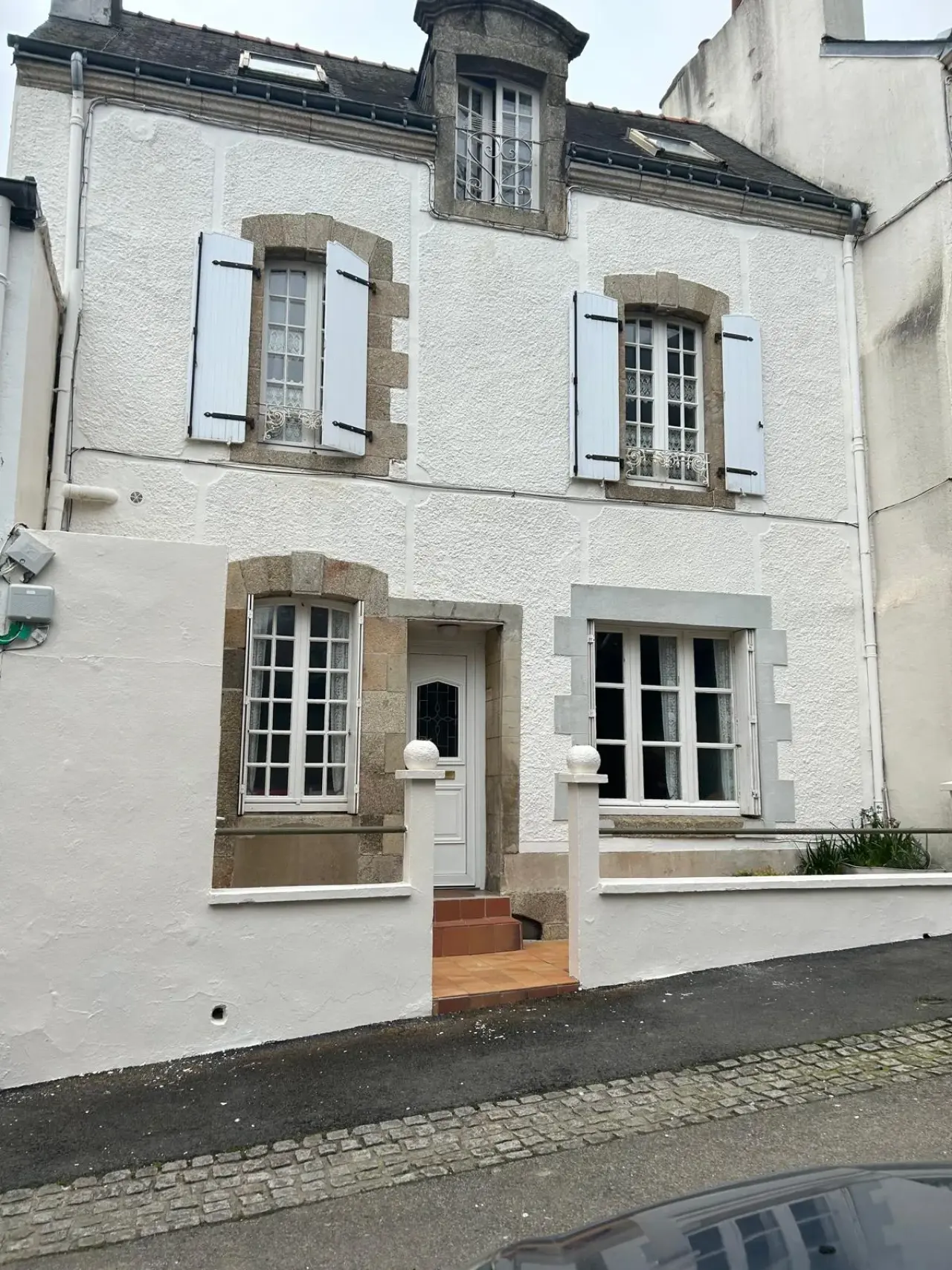 Façade de maison à étage en crépi blanc, après ravalement
