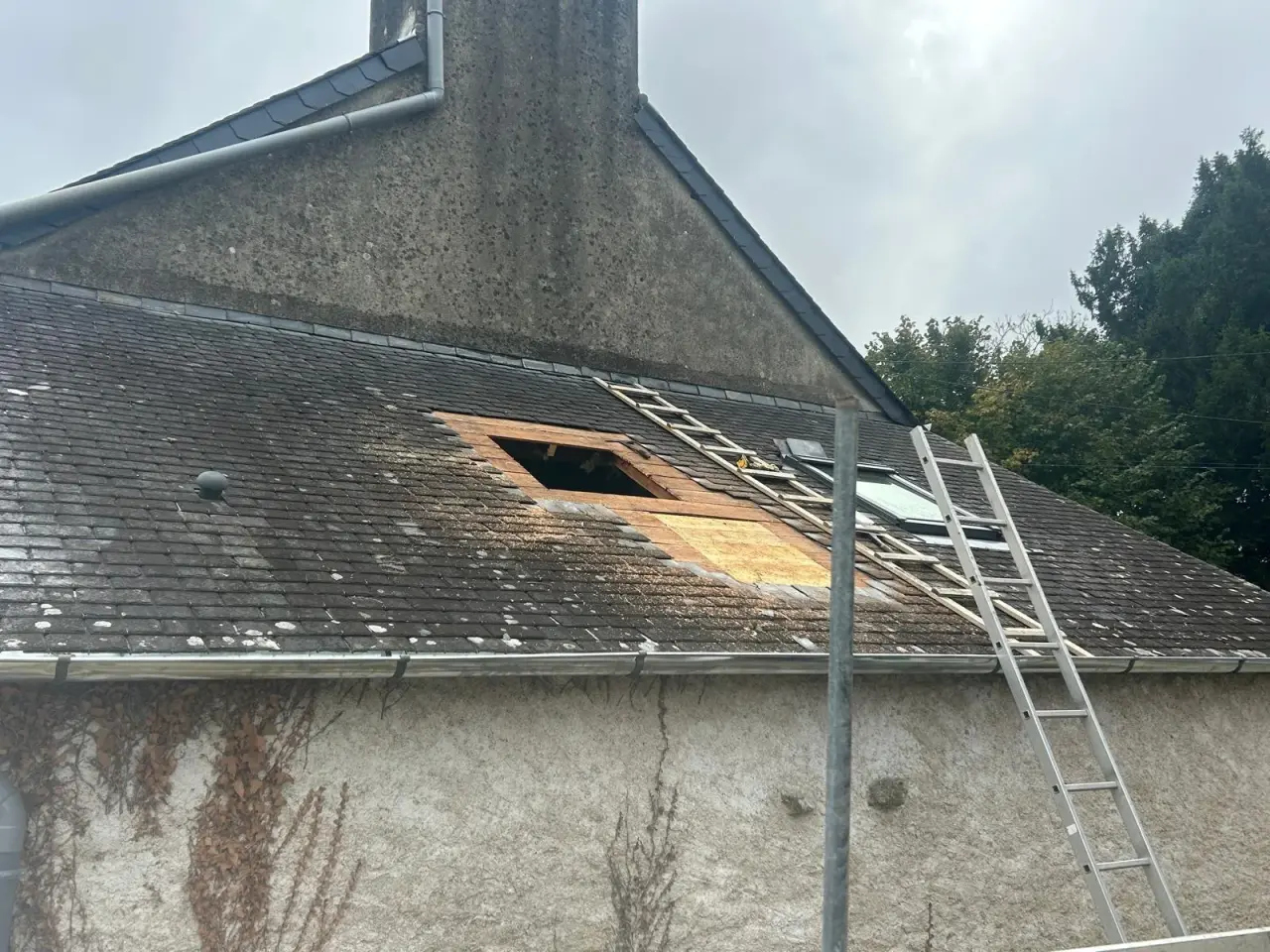 Ouverture découpée dans une toiture en tuiles, avant la pose de la fenêtre de toit