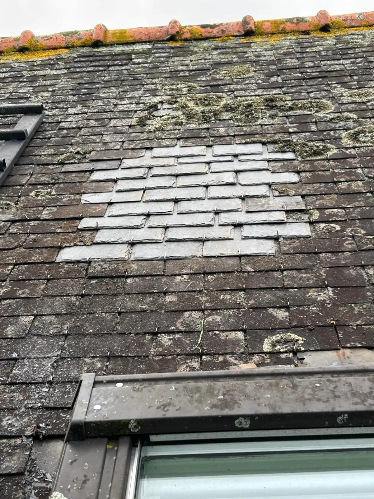 Pourtour d'une fenêtre de toit repris sur une toiture d'ardoises